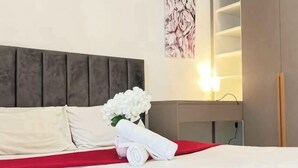 A neatly made bed with white linens, a red blanket, and a bouquet of white flowers. - The Transit Loft - Warisan StayHub (Dengkil)