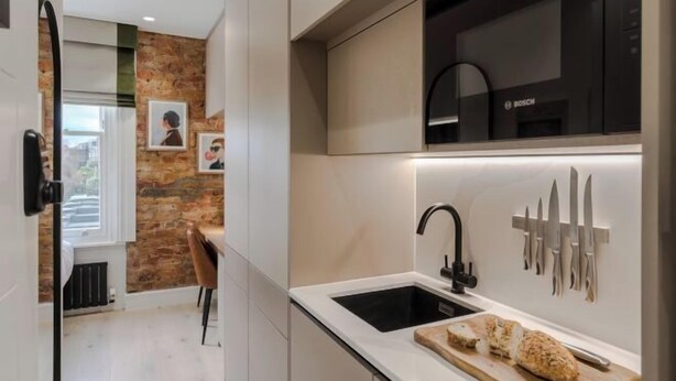 A modern kitchen with a Bosch oven, a sink, and a knife rack. - Kensington Cosy Studio (London)