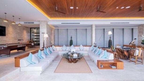 A modern living room with a large sectional sofa, a coffee table, and a pool table. - Maya Anda Villa (Phuket)
