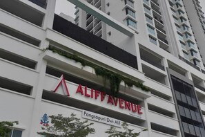 Un immeuble à plusieurs étages, sur lequel on peut voir une enseigne bien visible indiquant « ALIFF AVENUE ».