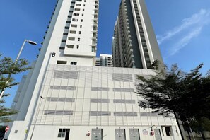 Un immeuble de grande hauteur à l’architecture moderne, caractérisé par un grand « B » bien visible sur sa façade, et avec un ciel dégagé en arrière-plan.