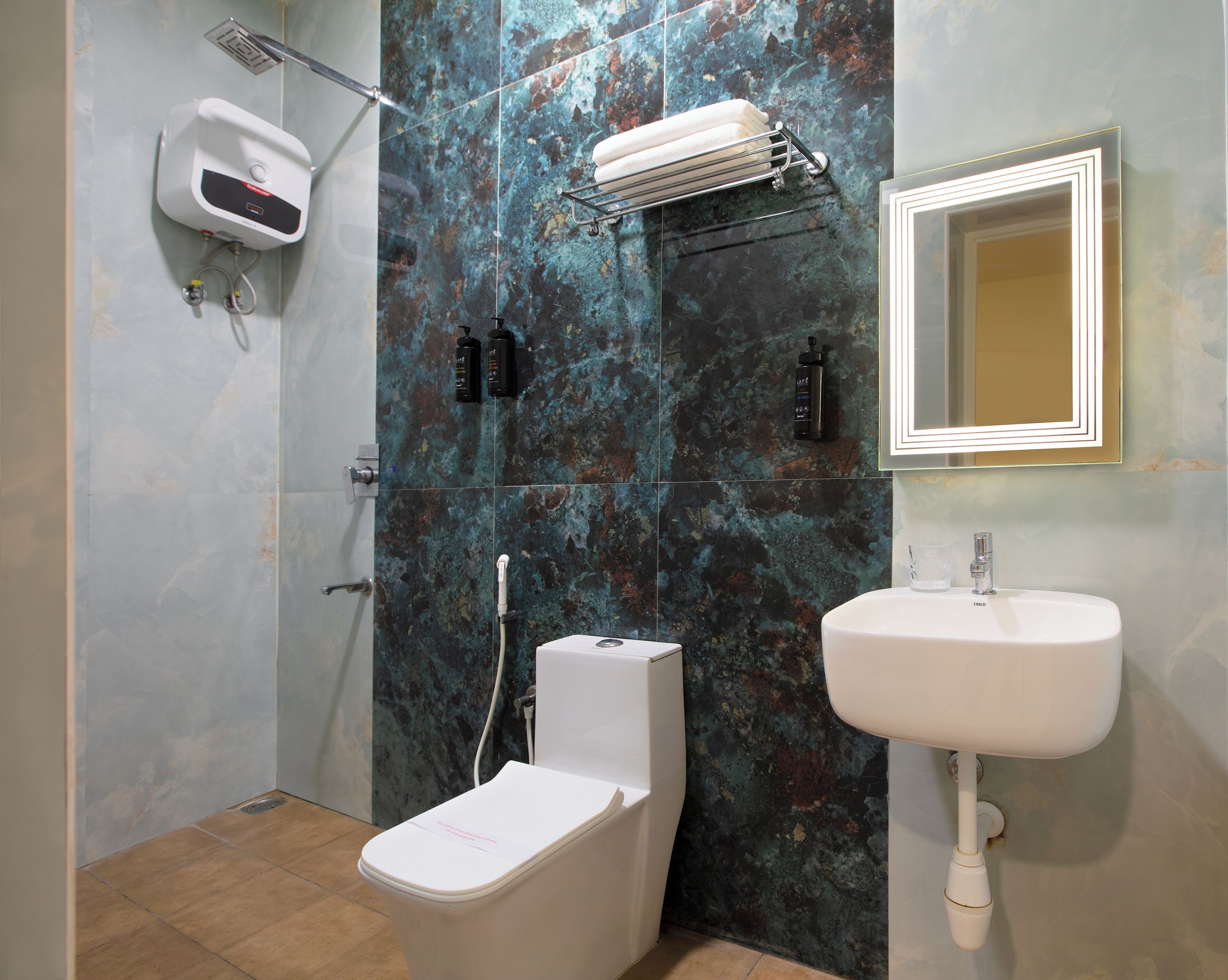 Un baño con ducha, inodoro, lavabo y espejo.