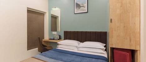 Un dormitorio ordenado con cama, escritorio y armario.
