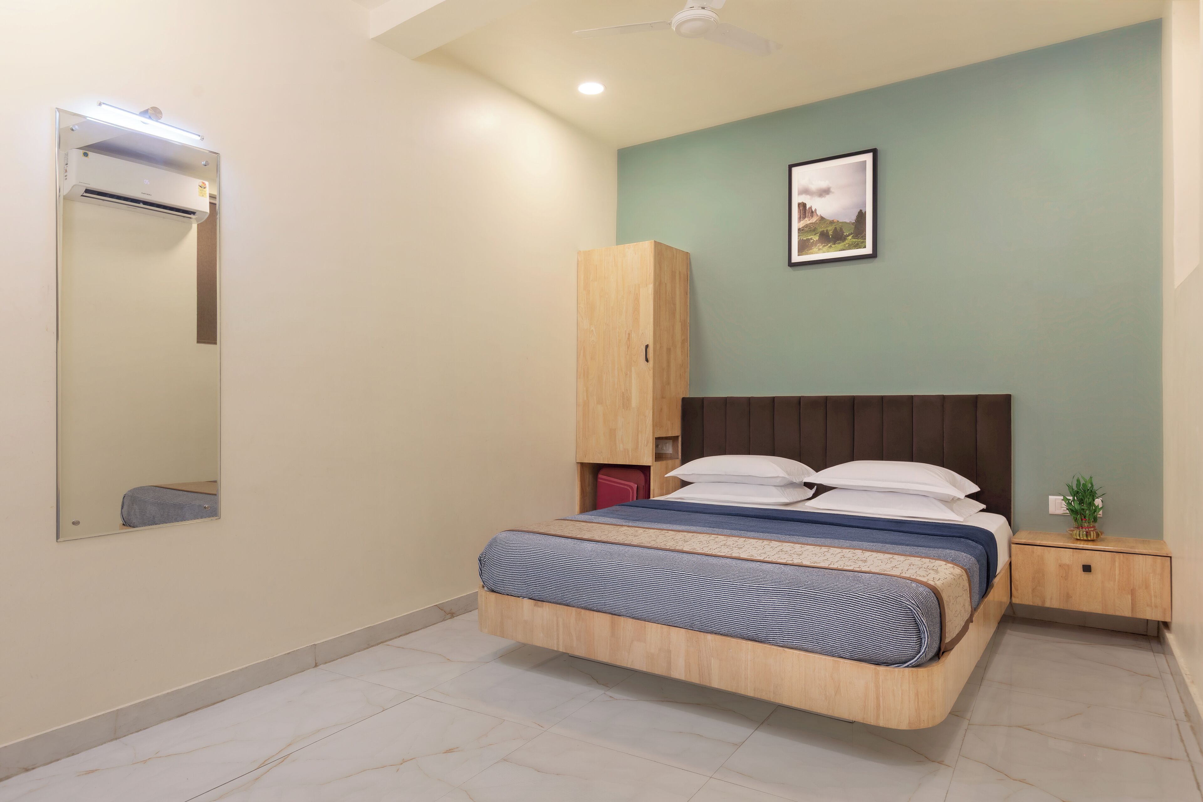 Une chambre à coucher comprenant un lit, une armoire, une table de chevet et un ventilateur de plafond.