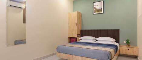 Un dormitorio con cama, armario, mesita de noche y ventilador de techo.