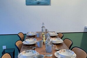 A dining table set with plates, bowls, and a pitcher, surrounded by chairs. - M Vertica KL City 4 Bedroom Fully Air-Con Suite (Kuala Lumpur)