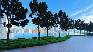 A waterfront promenade with trees and a city skyline in the background. - M Vertica KL City 4 Bedroom Fully Air-Con Suite (Kuala Lumpur)
