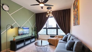 A modern living room with a sofa, a coffee table, a TV, and a ceiling fan. - M Vertica KL City 4 Bedroom Fully Air-Con Suite (Kuala Lumpur)