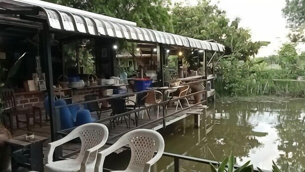 A riverside restaurant with outdoor seating, a covered area, and a view of the water. - Ingna Resort (Chanuman)