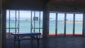 A room with a large sliding glass door leading to a beach view. - ZZOKIAI Blue Fish! Only 2 mins to beach by walk! Maximun 11 persons! (Itoman)