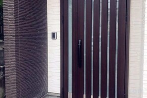 A dark brown sliding door with a handle, set in a brick wall. - ZZOKIAI Blue Fish! Only 2 mins to beach by walk! Maximun 11 persons! (Itoman)