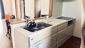 A compact kitchen with a sink, countertop, and cabinets. - ZZOKIAI Blue Fish! Only 2 mins to beach by walk! Maximun 11 persons! (Itoman)