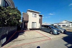 A residential area with a modern two-story house, a parking lot, and a parked van. - ZZOKIAI Blue Fish! Only 2 mins to beach by walk! Maximun 11 persons! (Itoman)