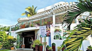 A modern building with a curved facade, a balcony with a railing, and a sign advertising a Sunday brunch. - Nicole's Garden Naga (Naga)