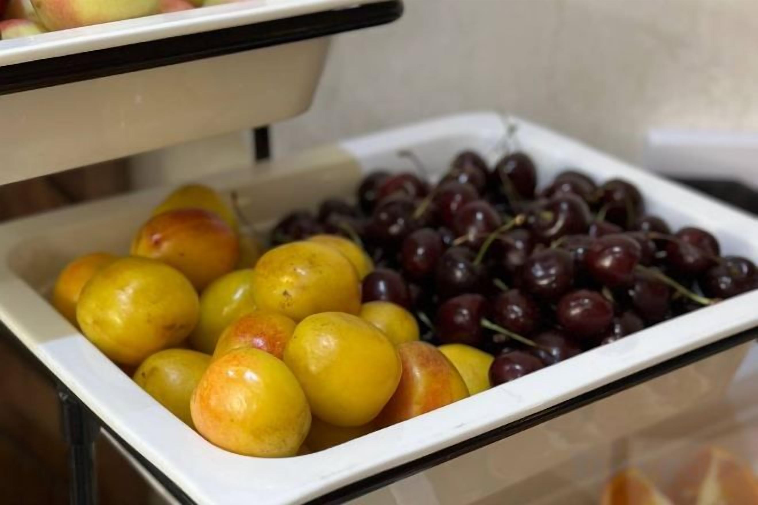 Un bufé con una variedad de frutas, incluyendo opciones amarillas y rojas.