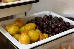 A buffet with a variety of fruits including yellow and red items. - ZA'Faron Hotel Jizzax-Department of Management Only (Jizzakh District)