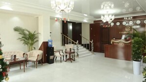 A hotel lobby with a reception desk, seating area, and staircase. - ZA'Faron Hotel Jizzax-Department of Management Only (Jizzakh District)