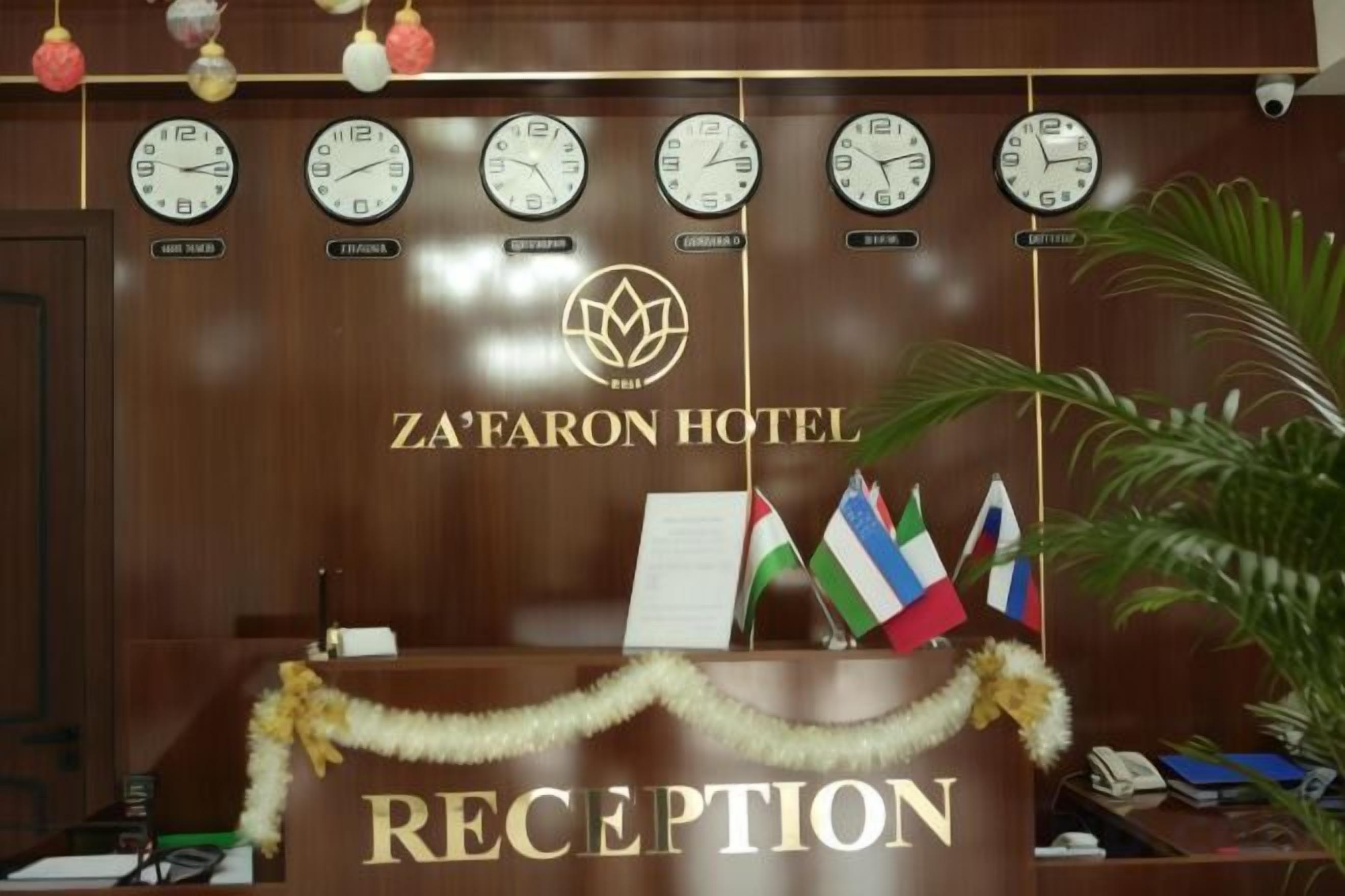A reception desk with clocks, flags, and a garland.