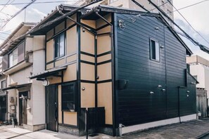 A two-story residential building with a dark exterior and a beige lower floor. - KoKoRoGo (Kyoto)