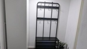 A corner room with a black metal shelf unit against the wall, a small step, and a potted plant. - Q Apartment No. 1 in BS Life close to the city (Braunschweig)