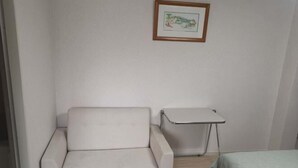 A small, clean room with a white sofa, a small table, and a bed. - Shin Awaji Building II, 202 Heart House,1 minute from Awaji Station. (Osaka)