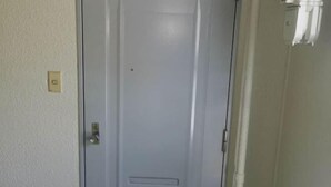 A closed door with a handle and a keyhole, a light switch on the wall, and a partial view of a window with blinds. - Shin Awaji Building II, 202 Heart House,1 minute from Awaji Station. (Osaka)