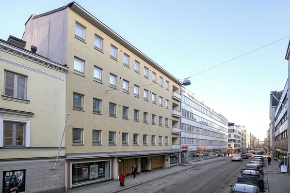 A multi-story building with a row of shops on the ground floor. - Kotimaailma Aparthotel Kamppi - 1BR for 3 (Helsinki)