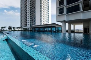 A swimming pool with clear blue water, surrounded by modern buildings.