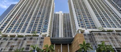 A high-rise building with multiple floors, large windows, and a central entrance area.
