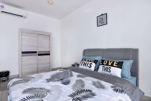 A bedroom with a bed, grey headboard, and two pillows with text. - Lovely Studio Trefoil Near Setia City Mall & SCCC (Shah Alam)