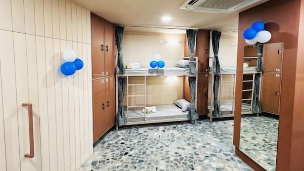 A room with bunk beds, a tiled floor, and a mirror with a balloon decoration. - Urban Bunk Beds (Rajkot)