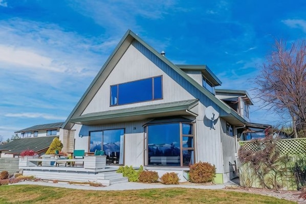 A modern two-story house with large windows, a visible deck, and a well-maintained lawn. - The Lake House (Lake Tekapo)