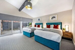 A bedroom with two beds, a large sliding glass door to a balcony, and a ceiling light fixture. - Host & Stay The Coachouse at Pilgrim St (Liverpool)