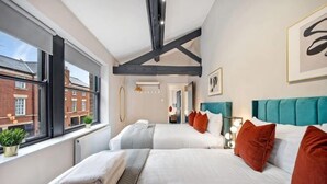 A hotel room with two beds, a view of the city, and a modern design. - Host & Stay The Coachouse at Pilgrim St (Liverpool)