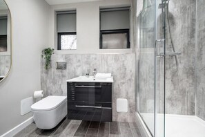 A modern bathroom with a toilet, sink, and shower. - Host & Stay The Coachouse at Pilgrim St (Liverpool)
