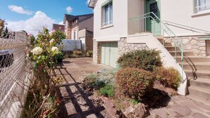 A residential building with a stone staircase, a green door, and a chain-link fence. - Cozy lodging near Chartres - 6 guests (Mainvilliers)
