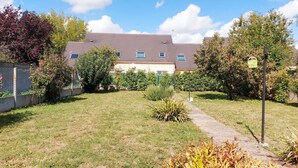 A residential building with a grassy yard, a pathway, and a fence. - Cozy lodging near Chartres - 6 guests (Mainvilliers)