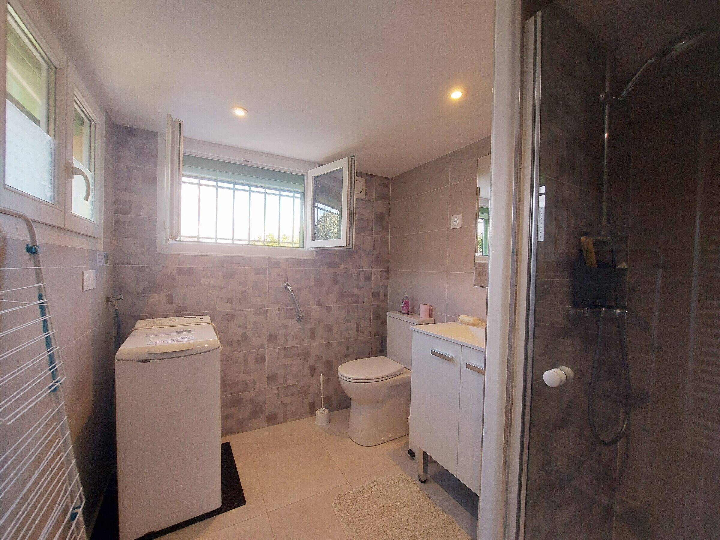 A compact bathroom with a toilet, sink, and shower.