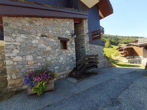 Un bâtiment en pierre avec un banc en bois et un jardinière.