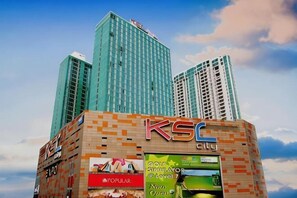 A KSC building with multiple high-rise structures, a prominent sign, and a visible advertisement for a golf course. - Apartment @ KSL D'Esplanade JB - 4R3B (Johor Bahru)