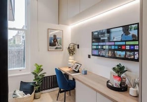 A modern office space with a desk, chair, and a large screen displaying multiple applications.