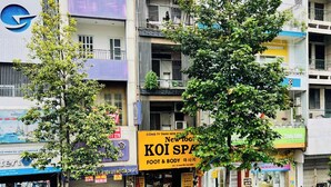 Un edificio de varios pisos con diversos comercios en la planta baja, incluyendo un spa y un restaurante a la vista.