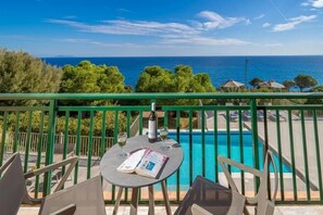 A balcony with a view of the sea, a pool, and outdoor seating. - Villa Niki with swimming pool (Elios Proni)