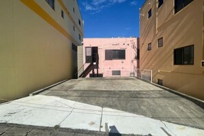 A narrow alleyway between two buildings with a concrete ground and a metal railing. - Shirahama no Kaze (Shirahama)