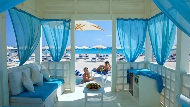 A beachside room with a view of the beach, a sofa, a table with a fruit bowl, and a small kitchenette. - Ghazala Luxury Collection Alamein (Qesm Ad Dabaah)