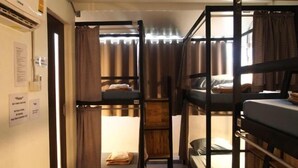 A bunk bed room with curtains, a wooden ladder, and a small table. - Dhub Hostel Donmueng (Bangkok)