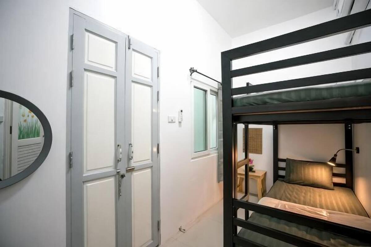 A bunk bed room with a door and a mirror.