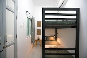 A bunk bed room with a window, a bedside table, and a wall-mounted shelf. - Dhub Hostel Donmueng (Bangkok)