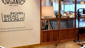 Interior de un restaurante con un separador de madera, una lámpara y una barra con alimentos.