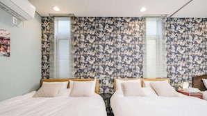 Une chambre d’hôtel avec deux lits, une petite table et une table de chevet.